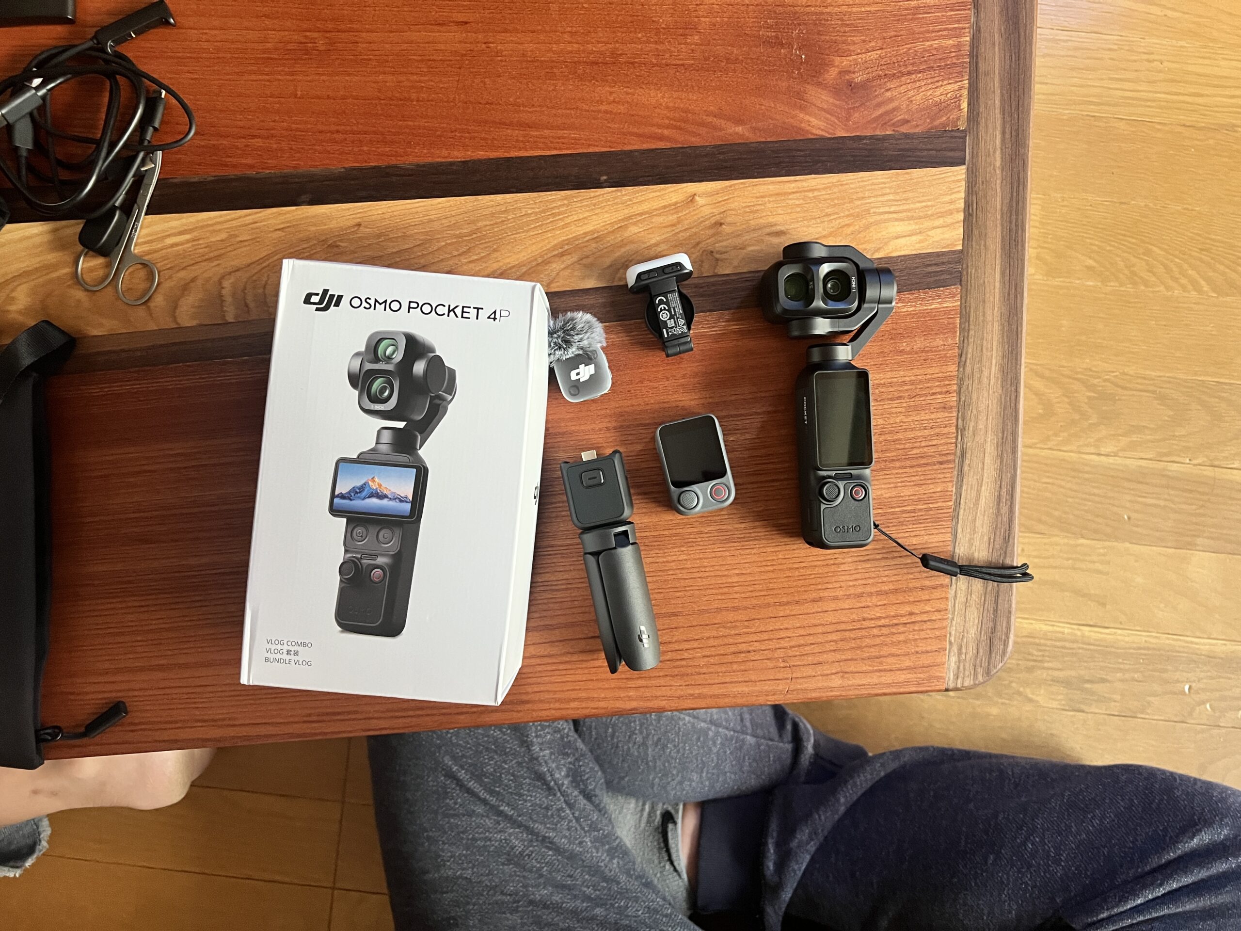 木の机に並べた購入したDJI Osmo Pocket 4P本体、箱と付属品